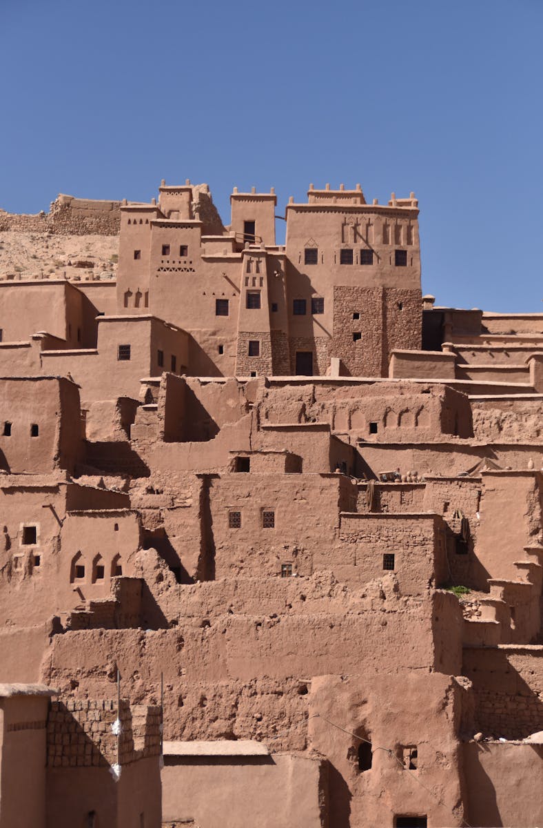 A stunning view of the historic mudbrick buildings of Aït-Ben-Haddou in Morocco under a clear blue sky.